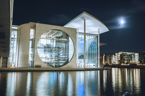 illuminated modern architecture in the government district in Berlin at night under moonlight