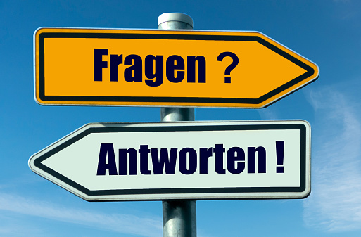 two direction signs with the german inscription: Questions?, Answers