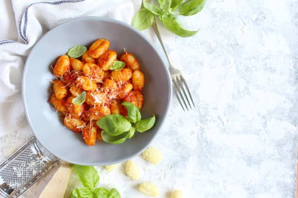 Italian homemade gnocchi with tomato sauce on light background. stock photo