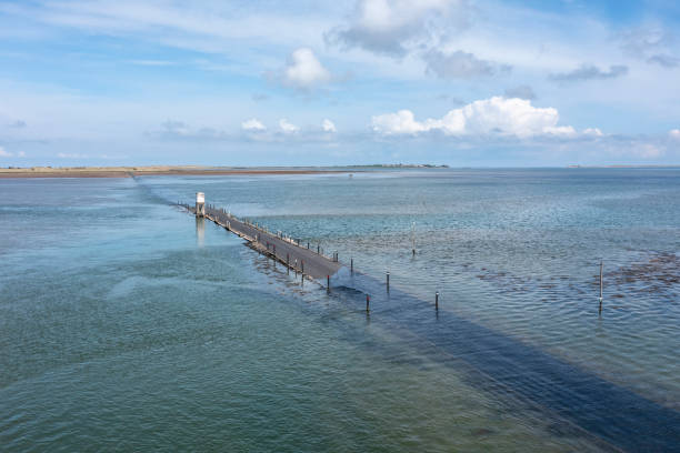 holy island causeway in der nähe von high tide - northumberland england lindisfarne northeastern england england stock-fotos und bilder