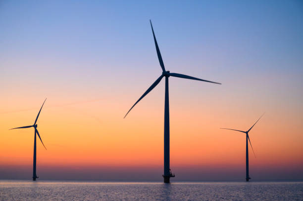 istock Wind turbines in an offshore wind park producing electricity during sunset. 1432896940