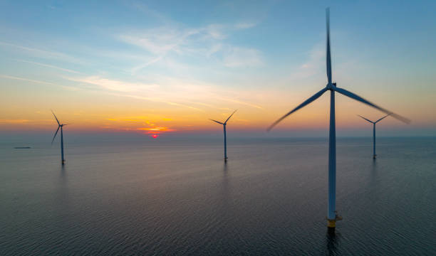 istock Wind turbines in an offshore wind park producing electricity during sunset. 1432896955