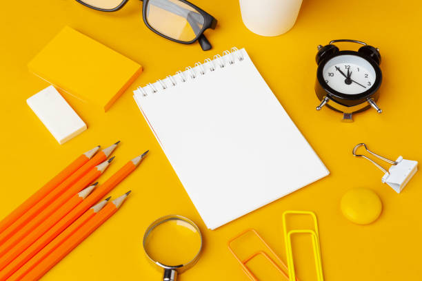 istock Stylish messy yellow desk top with various stationery top view 1432898086