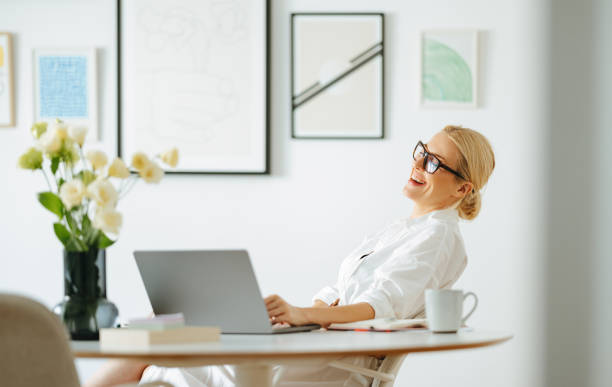 istock Cheerful Smiling Business Woman Using A Laptop Computer At Work 1432899271