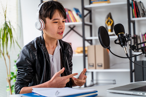 Teenager boy recording podcast at home