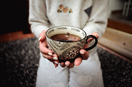 Hot drink. Woman holding a mug. Concept o winter comfort
