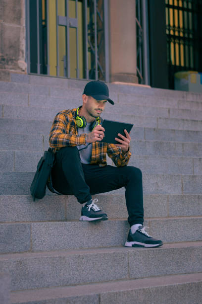 istock Man in a cap works remotely with a tablet at night 1432902599