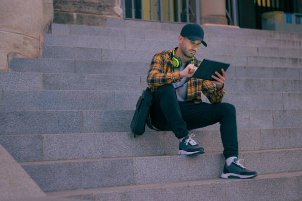 istock Man in a cap works remotely with a tablet at night 1432902605
