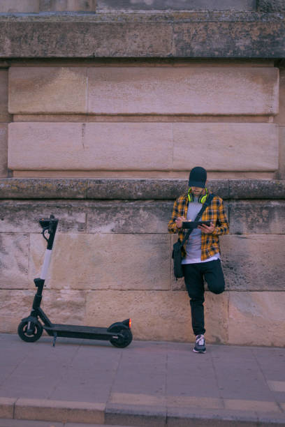 istock Man with a electric scooter works remotely with tablet at night 1432902609