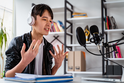 Teenager boy recording podcast at home