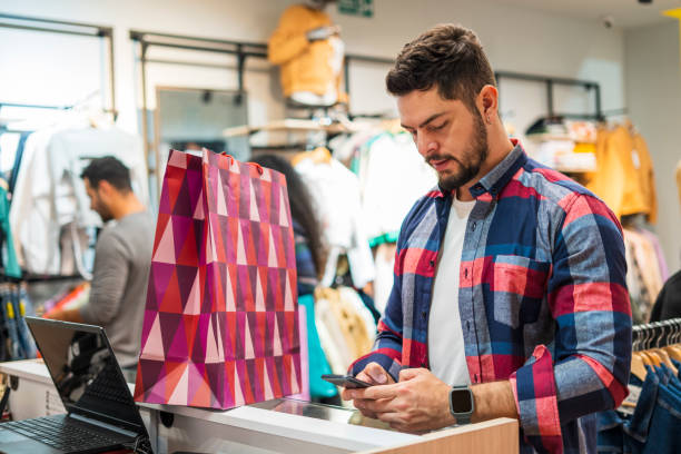istock young man is in a shopping mall while holding his cell phone in his hand 1432910186