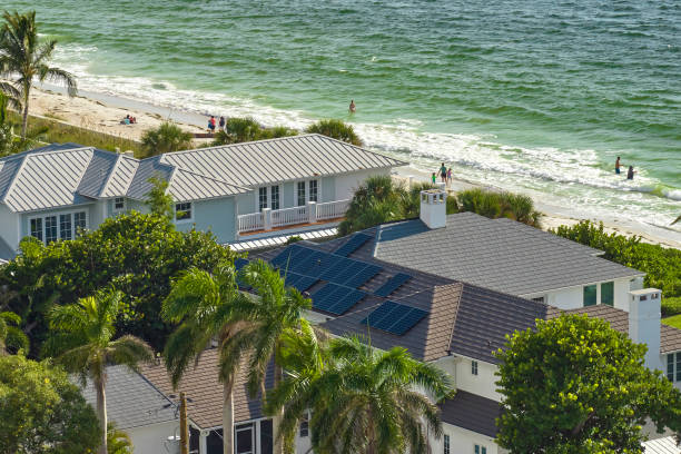 Aerial view of seaside expensive american home roof with blue solar photovoltaic panels for producing clean ecological electric energy. Renewable electricity with zero emission concept Aerial view of seaside expensive american home roof with blue solar photovoltaic panels for producing clean ecological electric energy. Renewable electricity with zero emission concept. florida real estate house home interior stock pictures, royalty-free photos & images