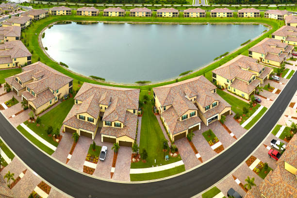 View from above of densely built residential houses near retention ponds in closed living clubs in south Florida. American dream homes as example of real estate development in US suburbs. vista desde arriba de casas residenciales densamente construidas cerca de estanques de retención en clubes cerrados en el sur de florida. las casas de ensueño americano como ejemplo de desarrollo inmobiliario en los suburbios de estados unidos