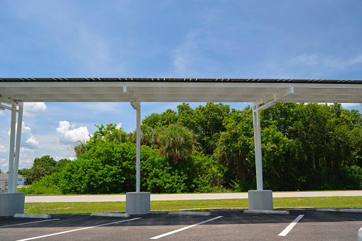 Solar panels installed over parking lot canopy shade for parked cars for effective generation of clean energy.
