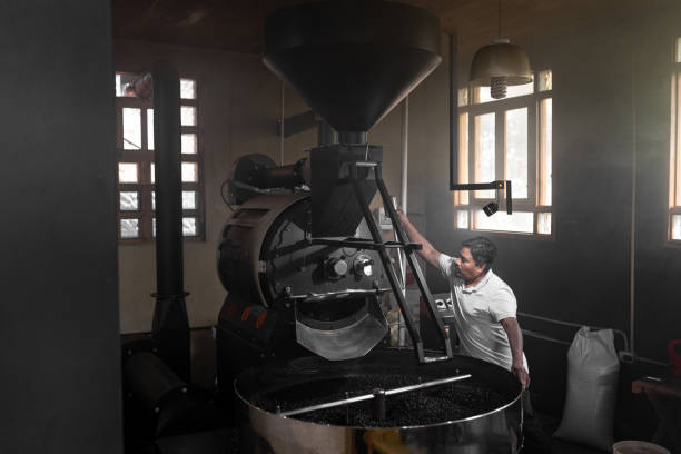 istock A Hispanic man is operating the lever of a coffee roaster machine 1432914047