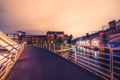 The modern Merchant’s Bridge in Castlefield Basin with the historical Victorian Rail Viaduct behind.