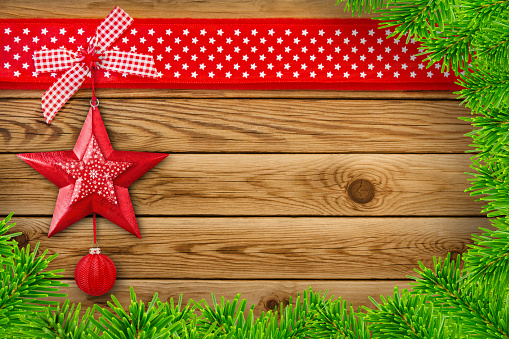 Red Christmas decoration with stars,  ornaments and fir branches on wooden background