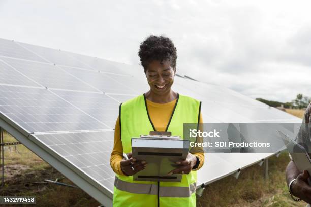 Female engineer smiling as she reads paperwork