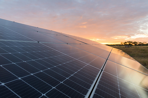 Solar panel photographed at an abstract angle with sunset in the background.