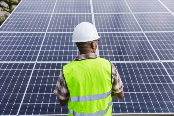 istock Solar farm inspector examining solar panels 1432919503