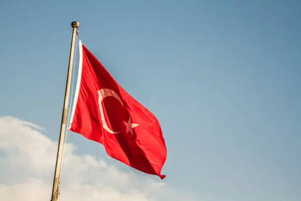 Turkish flag waving on blue skyClose view of red Turkish flag with crescent moon and star
