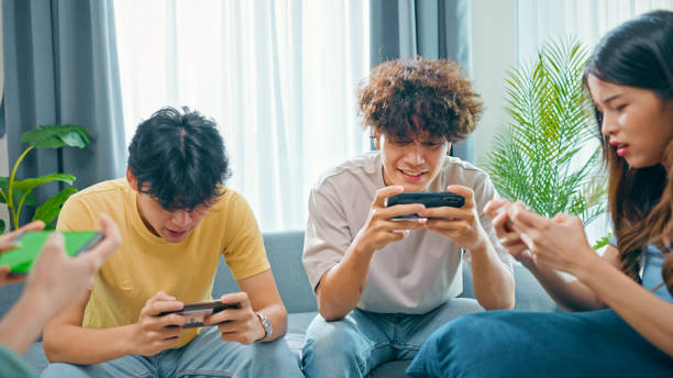 istock group of friends having fun together while playing games in smartphone 1432925021