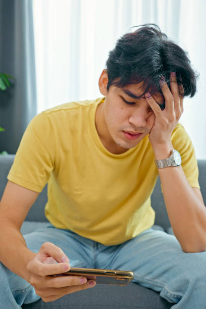 istock Worried Asian man playing games on his smartphone 1432925034