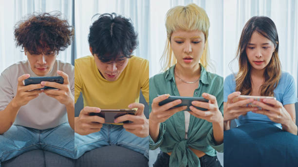 Multiple Screen group of Success people  having fun  while playing games in smartphone stock photo