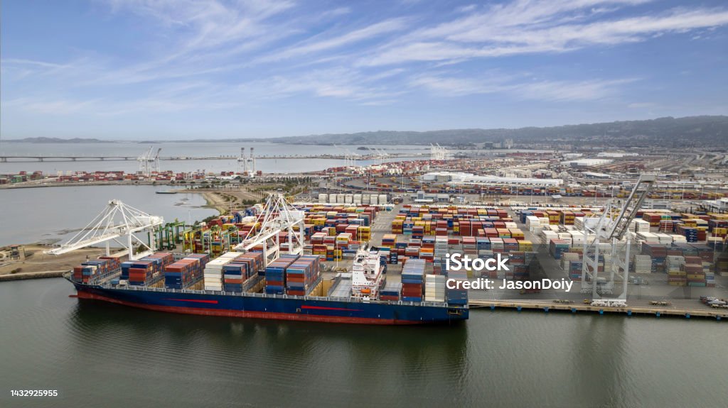 Port of Oakland Cargo Ships Aerial stock photos of large scale commercial shipping cargo container ships moored in Oakland alongside Alameda California. Commercial Dock Stock Photo