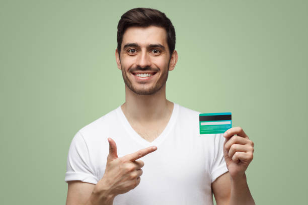 istock Man in white t-shirt showing credit card 1432926384