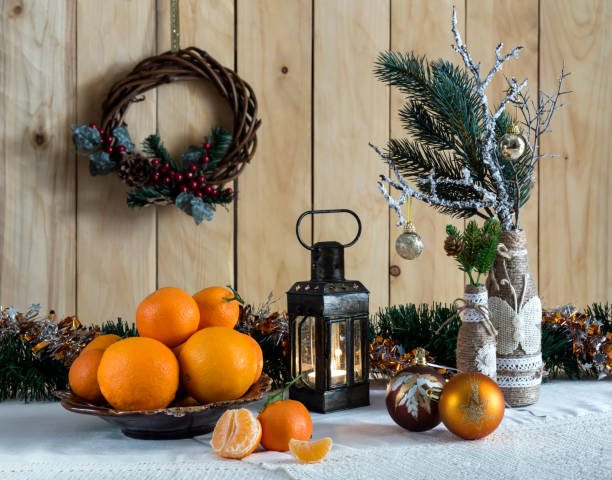 A variety of Christmas tree ornaments, oranges and tangerines on the table close-up.