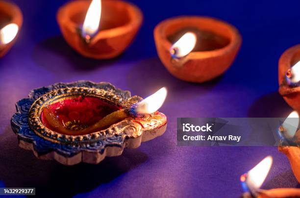 Closeup Of Diwali Diya Or Oil Lamp Flame With Selective Focus Isolated On Blue Background Happy Deepavali Or Diwali Conceptual Festival Of Lights Stock Photo - Download Image Now