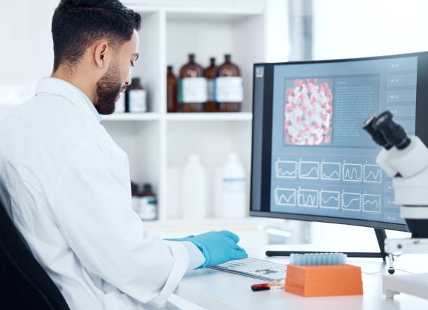 istock One mixed race scientist from the back analysing medical test samples and data from microbiology and genetic research on computer screen in lab. Young man developing cure for virus with biotechnology 1432929459