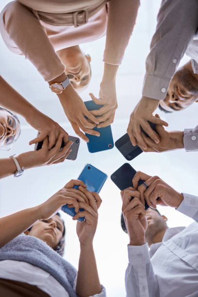 istock Social media, smartphone and business people networking with a global community using technology together. Group and team typing, surfing and searching online on web communication app from below view 1432932236