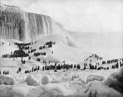 Incredible image of Niagara Falls frozen with people walking on ice.