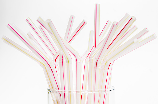 Red stripped straws in glass on white table