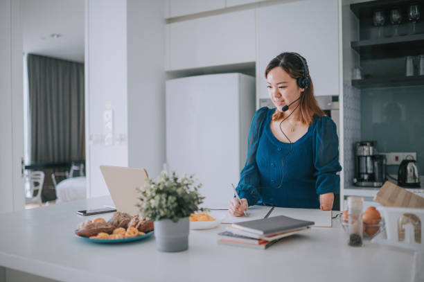 istock Chinese Woman with disability deformed arm work from home video call at kitchen counter business meeting virtual event 1432937353