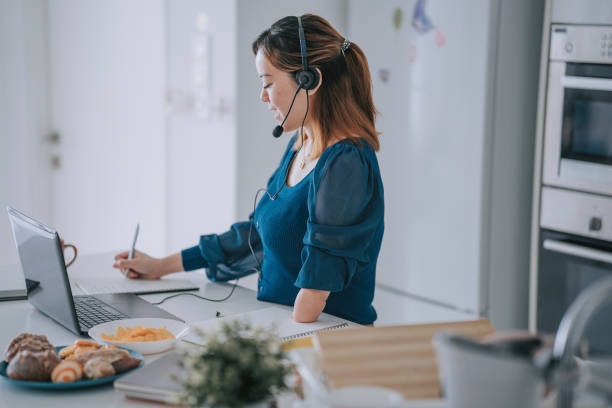 istock Chinese Woman with disability deformed arm work from home video call at kitchen counter business meeting virtual event 1432937398