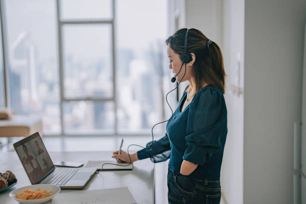 Chinese Woman with disability deformed arm work from home video call at kitchen counter business meeting virtual event