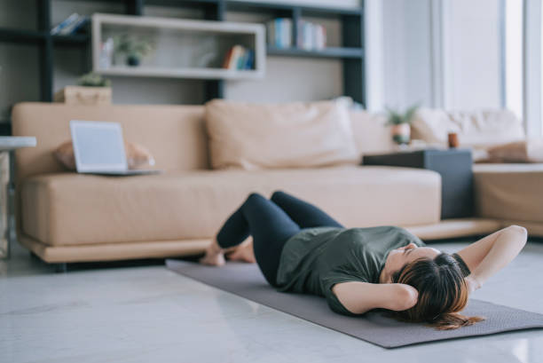 istock Chinese woman with disability deformed arm sit up home workout watching online class guidance with laptop 1432938148