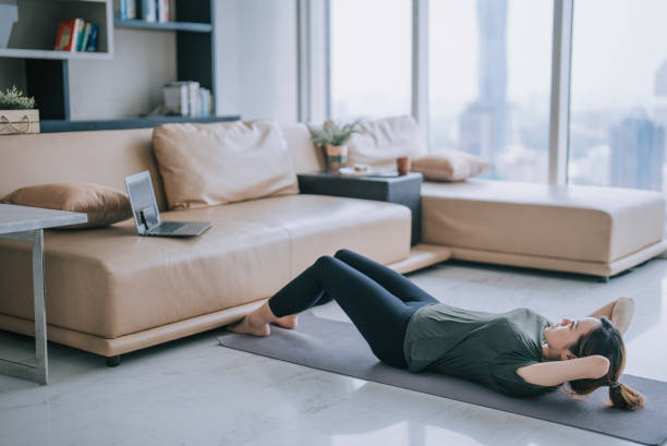 istock Chinese woman with disability deformed arm sit up home workout watching online class guidance with laptop 1432938150