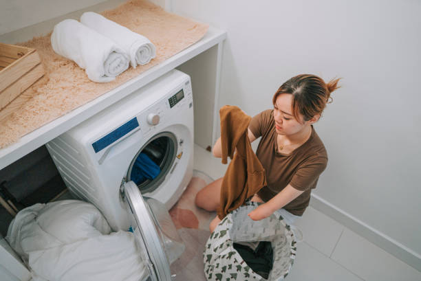 istock Asian chinese woman with disability deformed arm doing laundry at home 1432938269