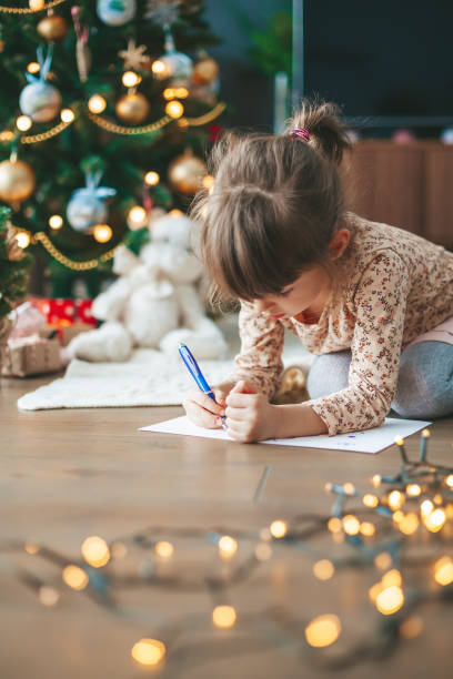 istock Girl writing a letter near Christmas tree 1432939771