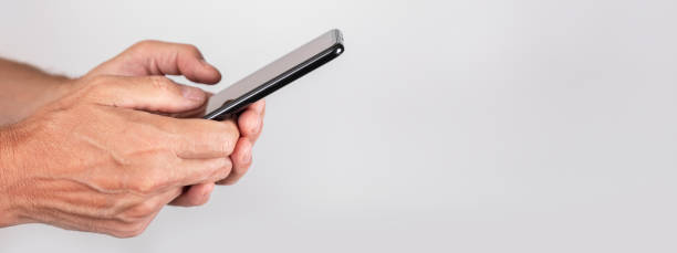 istock Hand holding mobile phone, smartphone, side view. Banner with background for text 1432941054