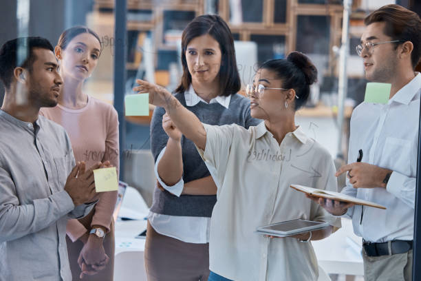istock Business people planning, strategy and project management training in teamwork collaboration and innovation meeting. Corporate manager, leader, group of employee or team working on idea with post it 1432941416