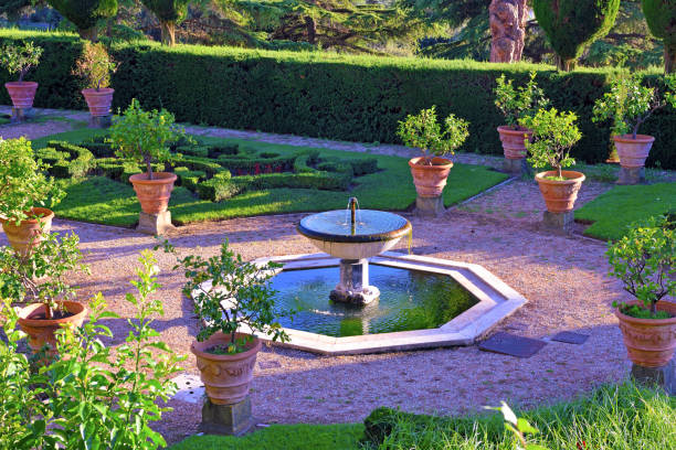 Solitary bench inside the famous garden of Villa Bardini in Florence with the wisteria pergola in bloom in the distance