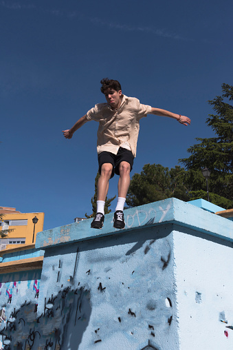 young male athlete doing parkour jumps and acrobatic exercises in the urban area of a city category urban gymnastics