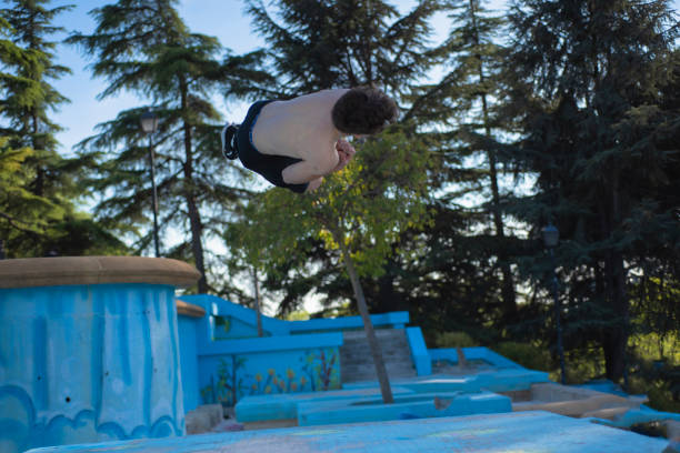 young male athlete doing parkour jumps and acrobatic exercises in the urban area of a city category urban gymnastics
