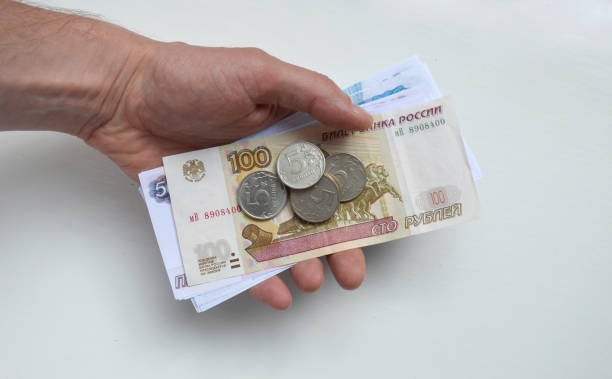 istock male hand with Russian rubles and coins on a white background 1432950226