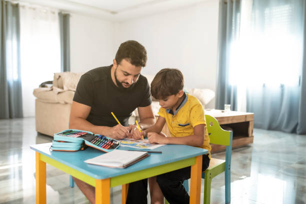 istock father helps son to do homework at home 1432951557